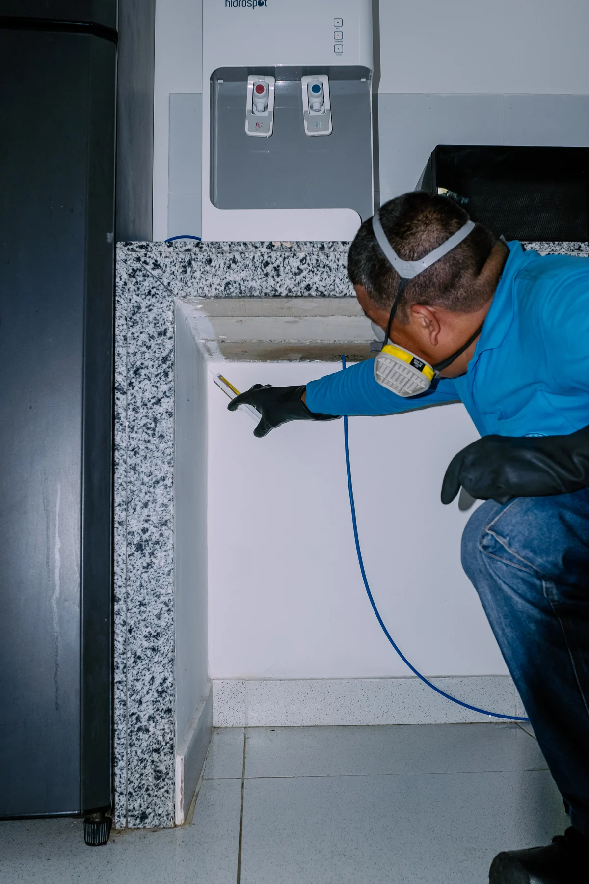 Tecnico de control de plagas aplicando gel cucarachicida